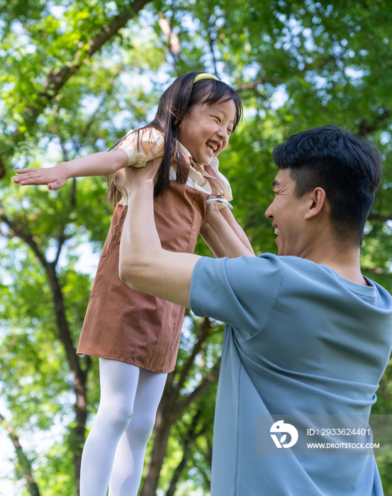 爸爸抱起女儿张开双臂转圈旋转