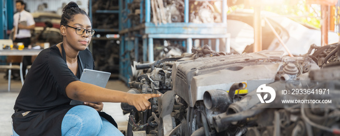 Portrait of confident African woman check and working in old parts of car factory