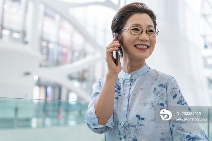 老年女人在机场打电话