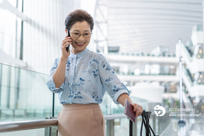 老年女人在机场打电话