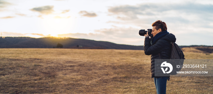 Woman photographer takes photos in the mountains