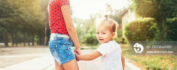 Two little sisters walking together in summer city park. Family values concept photo.