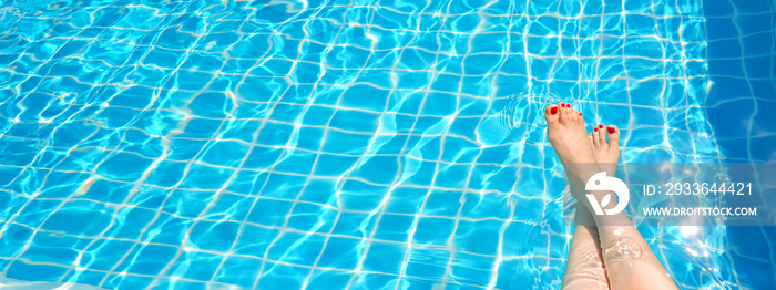 Feet in swimming pool water. Selfie of legs and barefoot with red pedicure and manicure nails on blue sea background. Vacation at summer holiday.