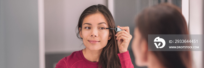 Mascara makeup beauty mirror Asian woman putting eye make-up getting ready in home bathroom panoramic banner.