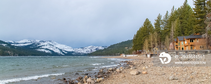 The Donner lake under the snow in winter, in the Nevada, with a chalet on the beach