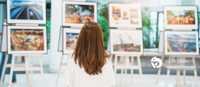 Young female tourist looking gallery exhibition. Art , photography and museum concept