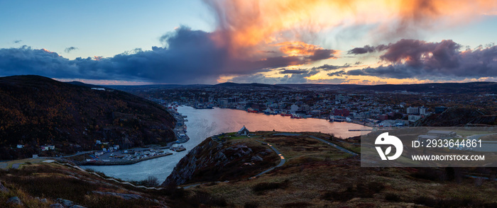 Aerial panoramic view of a modern cityscape on the Atlantic Ocean Coast during a dramatic sunset. Taken in St. John’s, Newfoundland and Labrador, Canada.