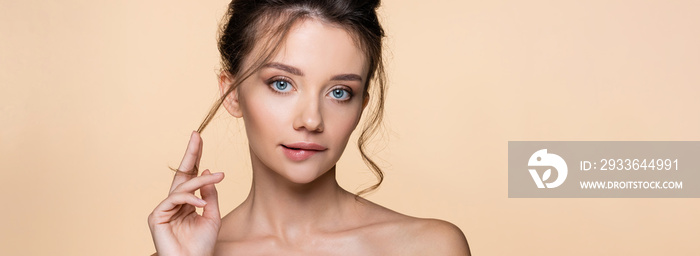 Young woman biting lip and looking at camera isolated on beige, banner.