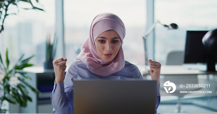 International office. Young beautiful arabic businesswoman wearing white hijab working on laptop in 