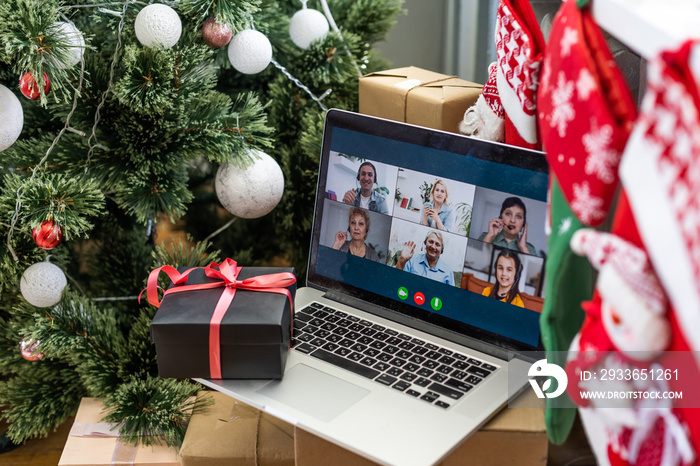 A happy family with a child is celebrating Christmas with their friends on video call using webcam. 