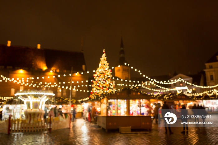 winter holidays and celebration concept - blurred christmas market in winter evening at town hall sq