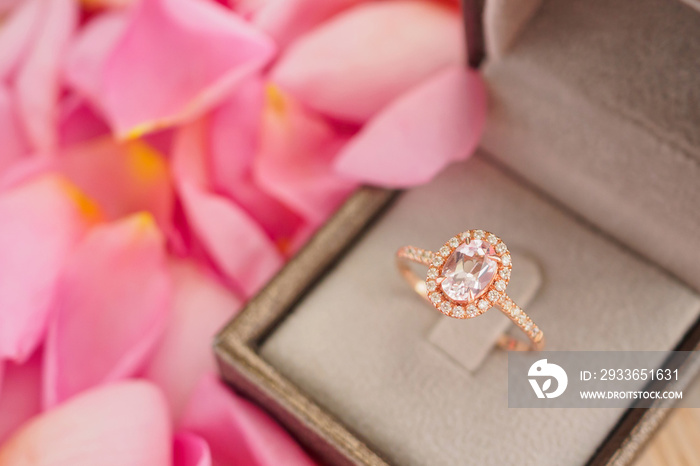 elegant wedding diamond ring in jewelry box on beautiful pink rose petal background close up