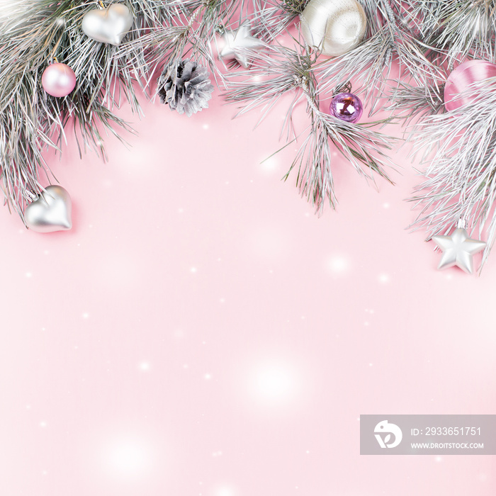 Christmas frame with fir branches, conifer cones, silver ornaments on pastel background with snow fa