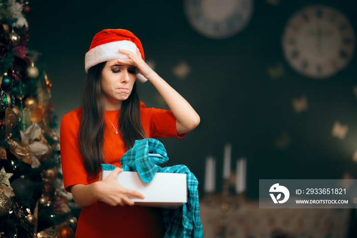 Upset Girl Opening a Bad Christmas Gift Finding Pajamas Inside