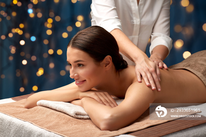 wellness, beauty and relaxation concept - beautiful young woman lying and having back massage at spa