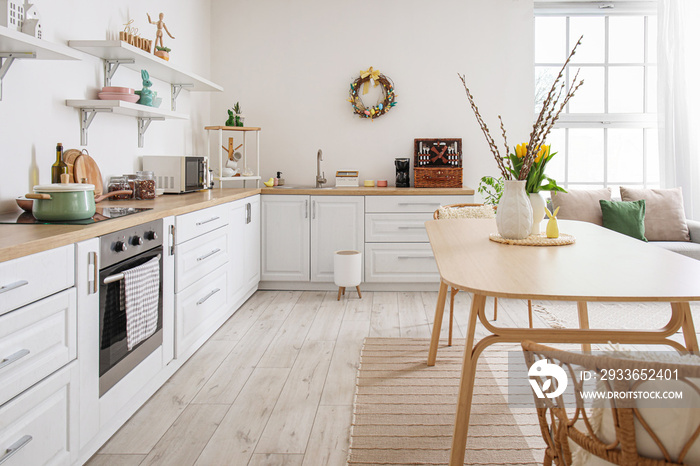 Interior of kitchen with Easter decor, white counters and dining table