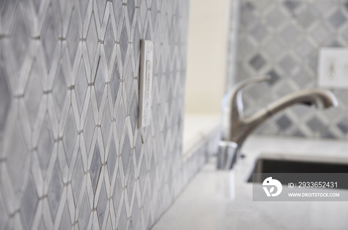 Gray kitchen tiles and faucet