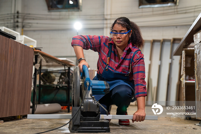 Young woman working as carpenter in a small carpentry workshop, Small family business concept of you