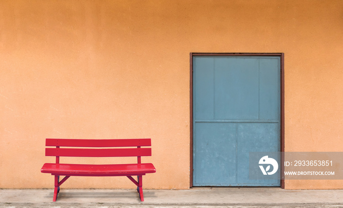 The red bench was placed in front of the room with orange walls.