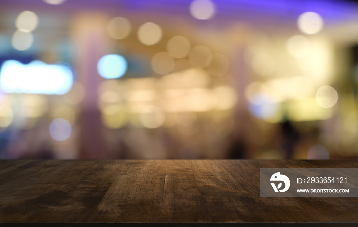 Empty dark wooden table in front of abstract blurred bokeh background of restaurant . can be used fo