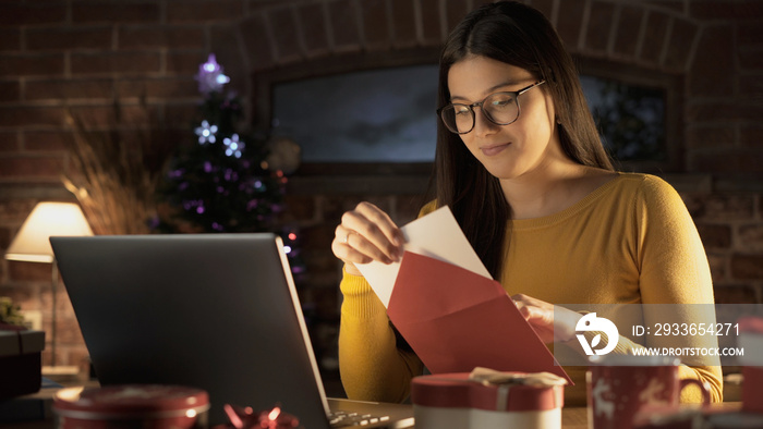 Young woman holding an envelope with a Christmas card