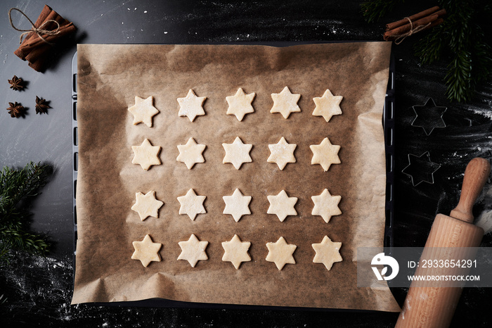 Top view of baking tray with raw star shaped cookies