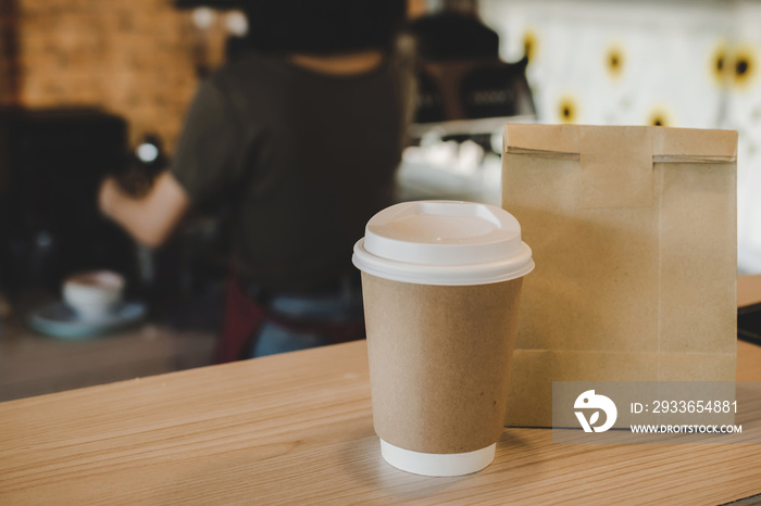 hot black coffee cup and dessert paper bag waiting for customer on counter in modern cafe coffee sho