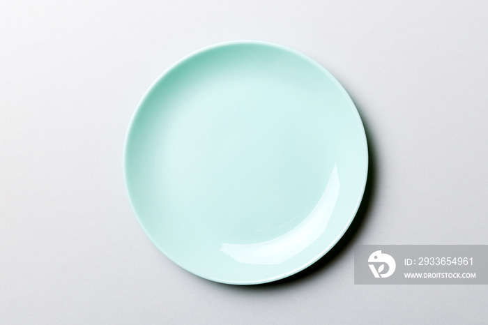 Top view of isolated of colored background empty round blue plate for food. Empty dish with space fo