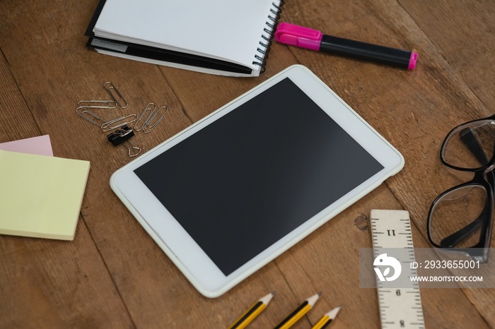 School supplies, digital tablet and spectacles on wooden table