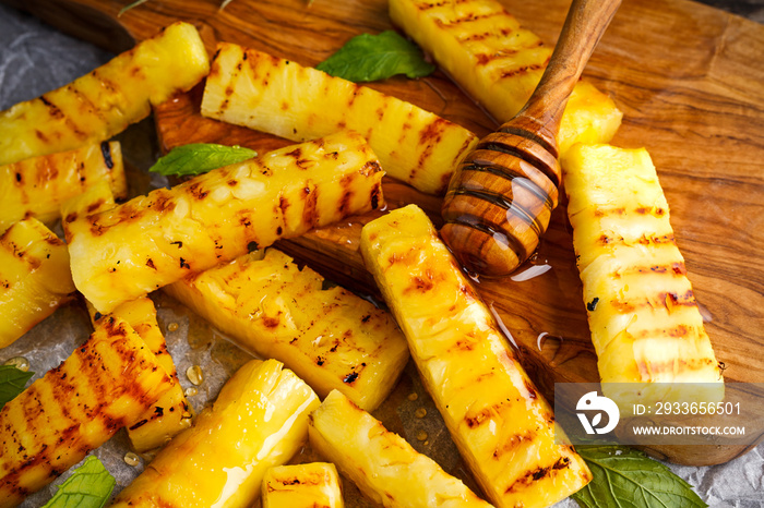 Grilled pineapple slices with honey on crumpled paper. selected focus