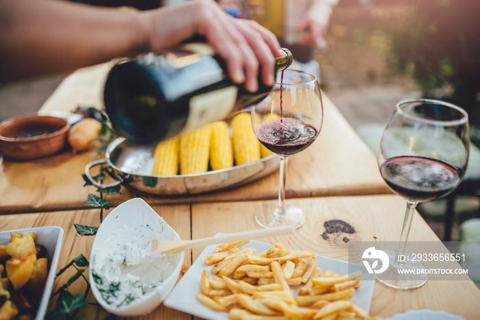 Close up photo of men pouring red wine