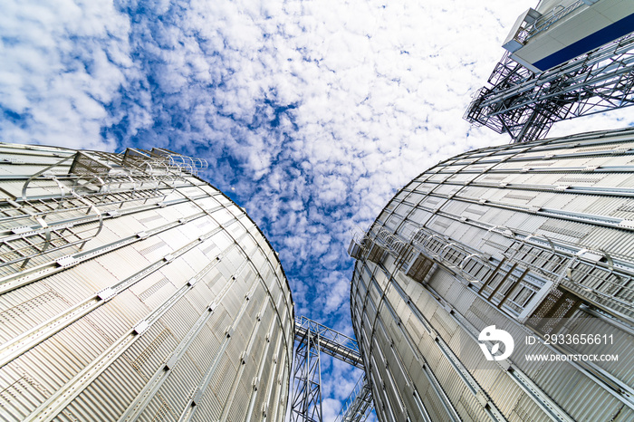 View from below on steel grain elevators. Modern up to date factory. Selective focus.