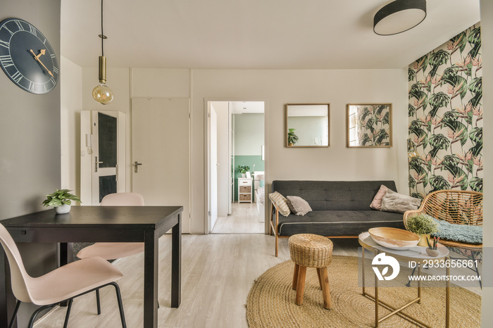 Table with chairs and flowers located near lounge area and kitchen in spacious room of contemporary 