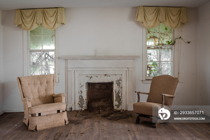 Living room with two chairs with a fireplace in an abandoned home