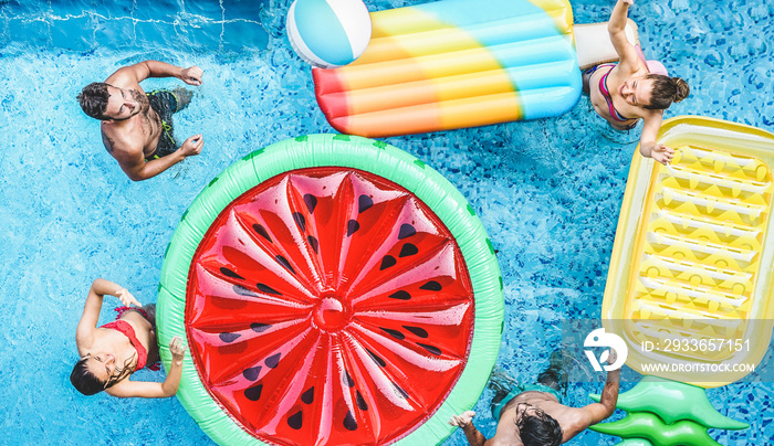 Happy friends playing with air lilo ball inside swimming pool