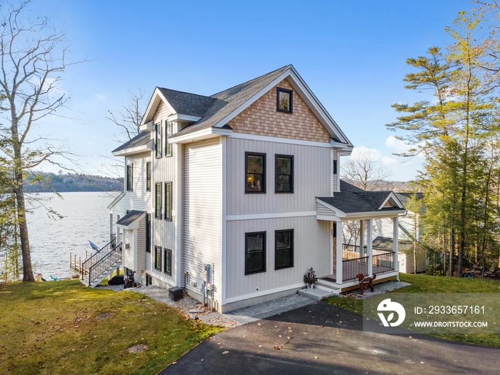 Scenic view of a beautiful white modern house near the lake on a sunny day