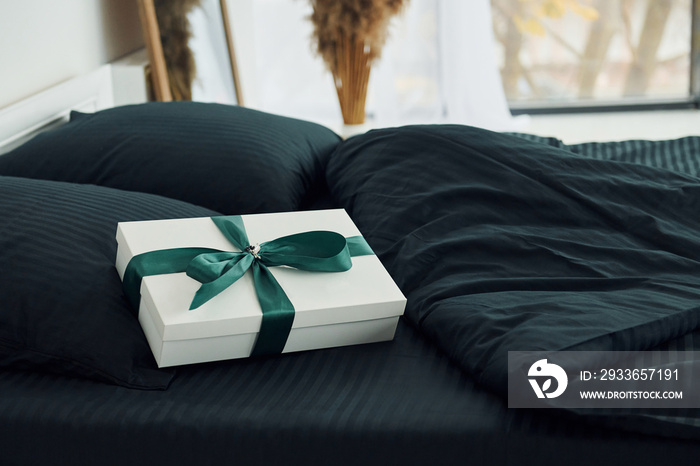 Gift box on bed. Interior and design of beautiful modern bedroom at daytime