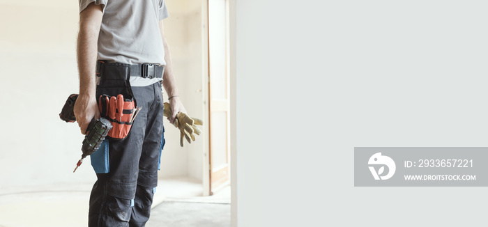 Professional repairman standing and holding a drill