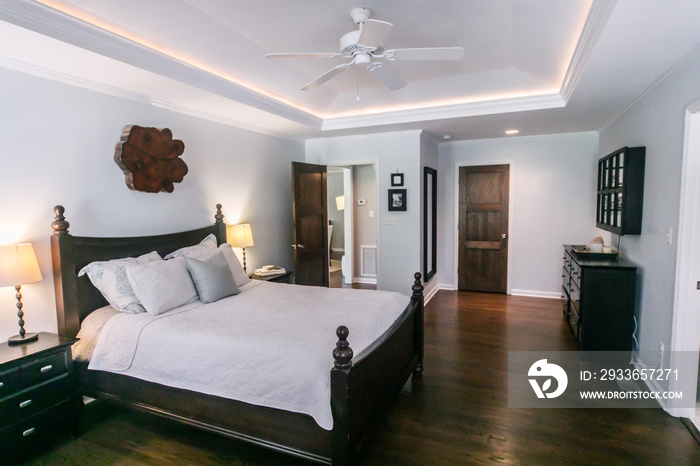 Master bedroom with king size bed and tray ceilings with uplighting and hradwood floors