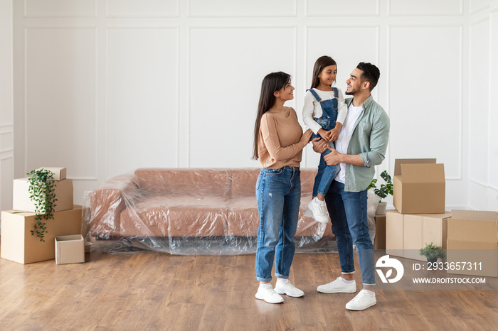 Young family looking at each other, posing in new flat