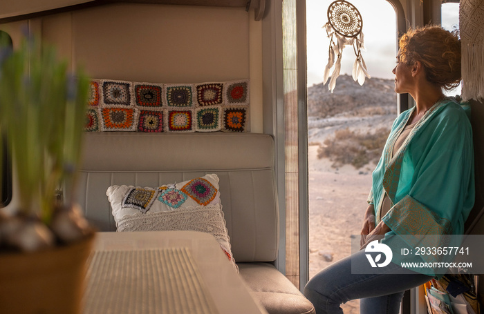 Travel lifestyle and daydreaming people. Woman standing onthe entrance door of her modern camper van