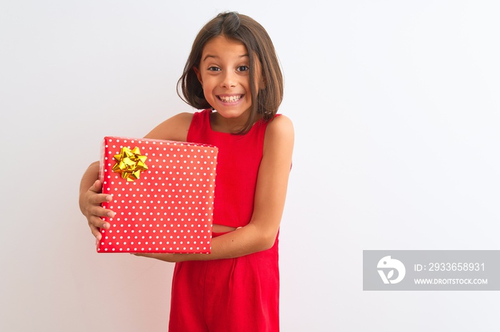 Beautiful child girl holding birthday gift standing over isolated white background with a happy face