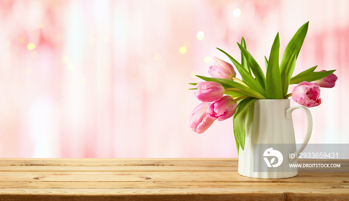 Beautiful tulip flower bouquet on wooden table over pink bokeh background. Valentines day or mother