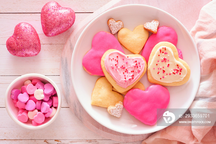 Heart shaped Valentines Day cookies with pink and white icing and sprinkles. Top view table scene ag