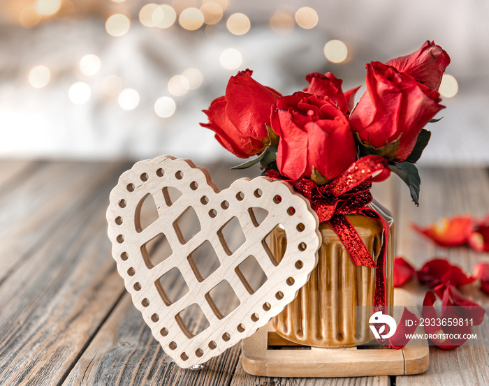 Composition for Valentines Day with roses in a vase and a decorative heart.