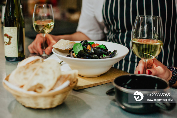 Couple having date in restaurant. Eating mussels and dribking white wine. St valentines day concept