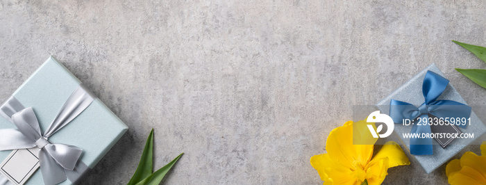 Mothers day background. Top view of gift with yellow tulip bouquet on gray table background