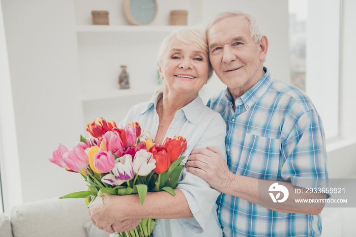 Photo of two adorable aged people hugging pair anniversary holiday surprise big red tulips bunch fla