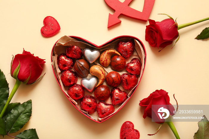 Heart shaped box with tasty chocolate candies and roses on beige background