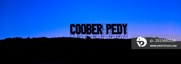 Banner panorama of the welcome road sign of Coober Pedy mining underground town in Australia at night. Located in the South Australian outback desert.